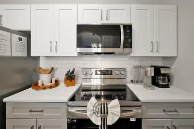 a kitchen with white cabinets and a stove top oven at Sunny Condo Retreat at Windsor Hills in Orlando
