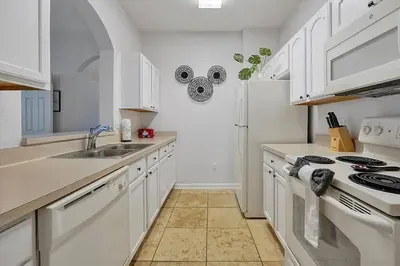 a white kitchen with a sink and a stove at Best Family Friendly Spot at Windsor Hills in Orlando
