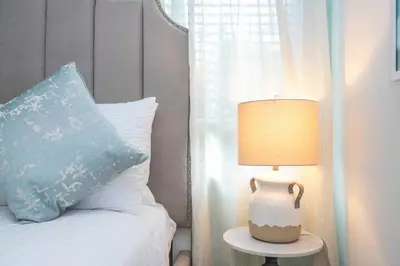 a bed with a blue pillow and a lamp on a table at NEW to Market 5 Bed - Storey Lake Retreat in Kissimmee