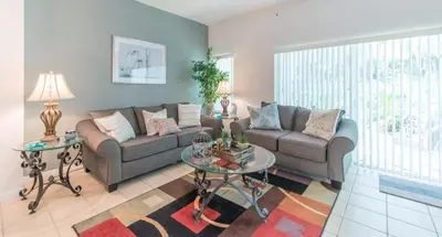 a living room with a couch and a table at Townhome at Emerald Island Resort in Kissimmee