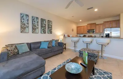 a living room with a couch and a kitchen at Private Pool Townhome at Paradise Palms Resort in Kissimmee