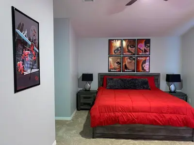 a bedroom with a red bed with posters on the wall at Minutes to Disney! Spacious Home w/ Private Pool, Themed Rooms! in Orlando