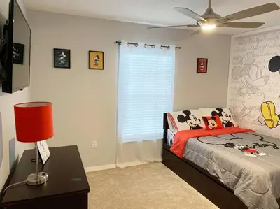 a bedroom with a bed and a ceiling fan at Minutes to Disney! Spacious Home w/ Private Pool, Themed Rooms! in Orlando