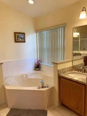 a large bathroom with a tub and a sink at Minutes to Disney! Spacious Home w/ Private Pool, Themed Rooms! in Orlando