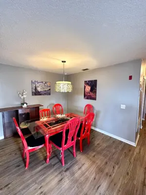 a dining room with a red table and red chairs at Grand Holiday 3BR Condo Resort near Disney Parks in Kissimmee