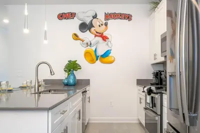 a kitchen with a mickey mouse wall decal at Wonderful 5 Bd w Pool @ Storey Lake Resort 2545 in Kissimmee