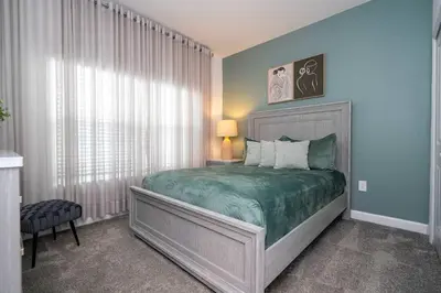 a bedroom with a bed with a green comforter at Free Waterpark 5Bd Close to Disney Private Pool 2497 in Kissimmee