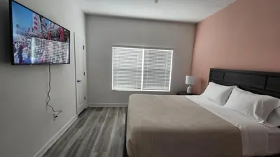 a bedroom with a bed and a television on a wall at COLORING in Kissimmee