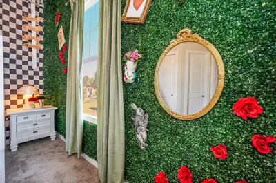 a green wall with a mirror and red roses at Magical Themed Home Near Disney in Orlando