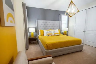 a bedroom with a yellow bed with two pillows at Stunning Luxury 9BR Encore Villa by Disney in Orlando