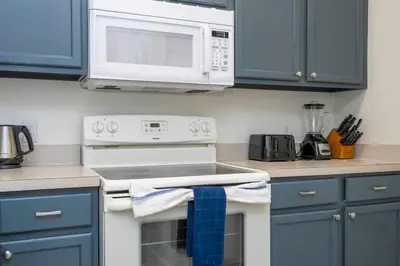 a kitchen with blue cabinets and a stove with a microwave at Marvelous 3Bd w Jacuzzi at Terra Verde Resort 4757 in Kissimmee