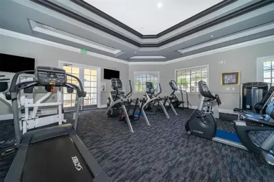 a gym with treadmills and ellipticals in a room at LC-8828-12-203DC - Legacy Dunes Condo for 6 guests in Kissimmee