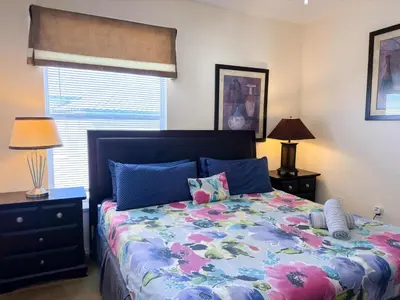 a bedroom with a bed and two lamps and a window at LD8830-12-308DC - Legacy Dunes condo for 8 guests in Kissimmee