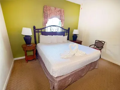 a bedroom with a bed with white sheets and two lamps at Best Disney Resort Condo Orlando in Orlando