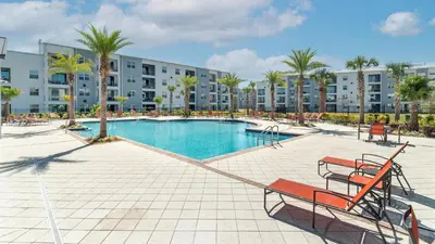 a swimming pool in a resort with palm trees and buildings at 3151 Paradox #306 in Kissimmee