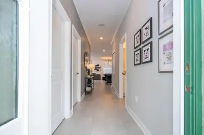 a hallway with white walls and white floors and a white door at Stunning 5 Bd w Pool at Storey Lake Resort 2400 in Kissimmee