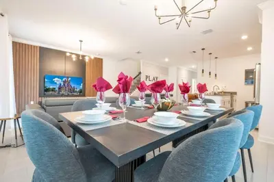 a dining room with a table and blue chairs at Stunning 5 Bd w Pool at Storey Lake Resort 2400 in Kissimmee