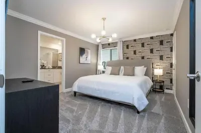 a bedroom with a large white bed and a bathroom at Stunning 5 Bd w Pool at Storey Lake Resort 2400 in Kissimmee