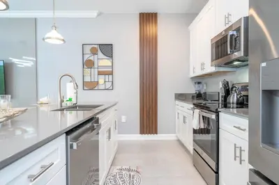 a kitchen with white cabinets and stainless steel appliances at Stunning 4 Bd w Pool @ Storey Lake Resort 2613 in Kissimmee