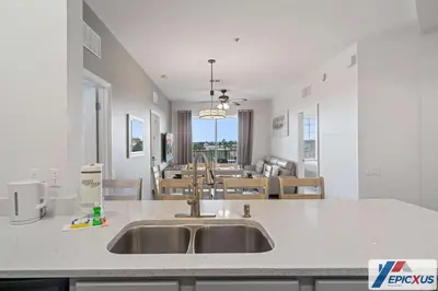 a kitchen with a sink and a dining room at The Epic Edinburgh Top Floor Vista Cay Orlando in Orlando
