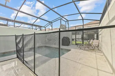 a glass house with a swimming pool and a patio at Home with a pool at Storey Lake Resort in Kissimmee