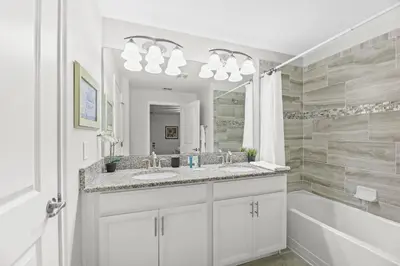 a bathroom with two sinks and a tub and a mirror at Home with a pool at Storey Lake Resort in Kissimmee