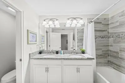 a bathroom with two sinks and a tub and a mirror at Home with a pool at Storey Lake Resort in Kissimmee