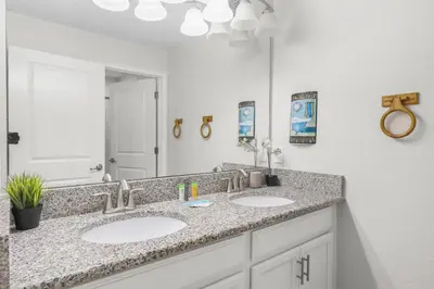 a bathroom with two sinks and a large mirror at Home with a pool at Storey Lake Resort in Kissimmee
