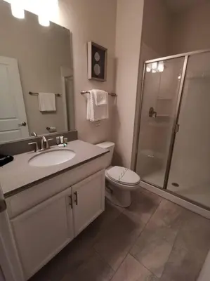 a bathroom with a toilet and a sink and a shower at Makin Memories Gated Resort Style Community Storey Lake in Kissimmee