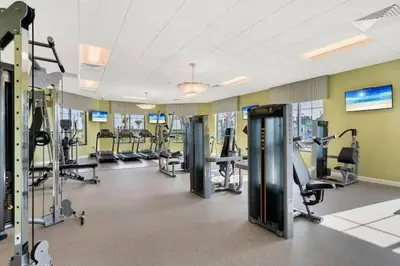 a gym with treadmills and machines in a building at Makin Memories Gated Resort Style Community Storey Lake in Kissimmee