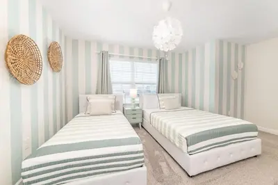 two beds in a room with striped walls at Disney Dream Home Prime Location Private Pool in Kissimmee
