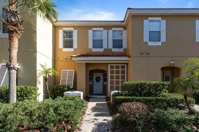 a house with a palm tree and bushes at Amazing 3Bdrms At Encantada- 6 miles from Disney in Kissimmee