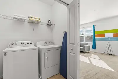a kitchen with a stove and a washing machine at Sunny Stay in Orlando - 6BR Home with Pool! in Kissimmee