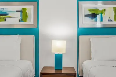 a bedroom with two beds and a table with a lamp at Sunny Stay in Orlando - 6BR Home with Pool! in Kissimmee