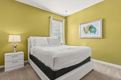 a bedroom with a white bed and a window at Sunny Stay in Orlando - 6BR Home with Pool! in Kissimmee