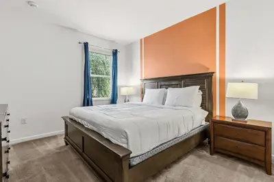 a bedroom with a large bed and a window at Sunny Stay in Orlando - 6BR Home with Pool! in Kissimmee