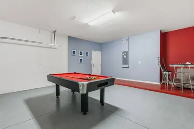 a room with a ping pong table in the middle at Sunny Stay in Orlando - 6BR Home with Pool! in Kissimmee