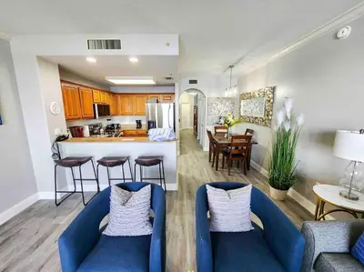 a kitchen and a living room with blue chairs in a room at Lakeview newly renovated condo near Disney in Orlando
