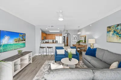 a living room with a gray couch and blue chairs at Lakeview newly renovated condo near Disney in Orlando