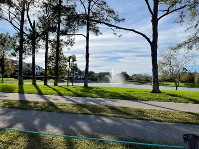 a park with a pond and trees and a fountain at House close Baldwin-park Lake & Downtown Orlando in Orlando