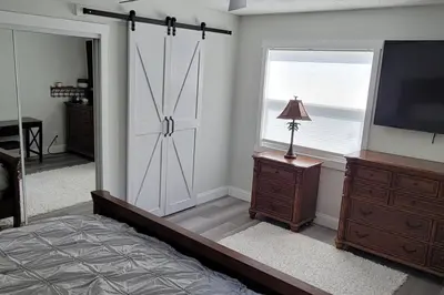 a bedroom with a bed and a television and a window at House close Baldwin-park Lake & Downtown Orlando in Orlando