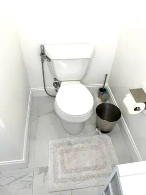a white bathroom with a toilet and a bucket at House close Baldwin-park Lake & Downtown Orlando in Orlando