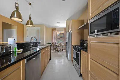 a large kitchen with a sink and a microwave at 4 BR Home w/ Resort Amenities + 3 Mi to Disney in Orlando