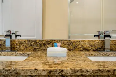 a bathroom counter with two sinks and two faucets at 4 BR Home w/ Resort Amenities + 3 Mi to Disney in Orlando