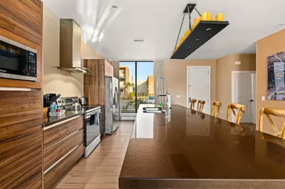a kitchen with wooden cabinets and stainless steel appliances at Outdoor Kitchen + 8 Min to Disney + Resort Cabanas in Orlando