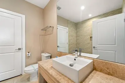 a bathroom with a white sink and a toilet at Outdoor Kitchen + 8 Min to Disney + Resort Cabanas in Orlando