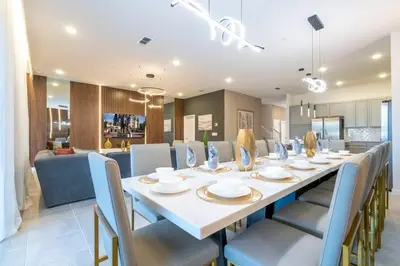 a dining room with a long table and blue chairs at 6163 Fantastic Home with 12BD in Orlando
