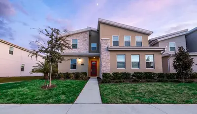 a large home with a red door and grass at Incredible 6BR Villa by Disney Private Pool Games in Kissimmee