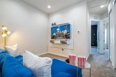 a living room with a blue couch and a tv at New Exclusive Villa 5 min to Disney in Orlando