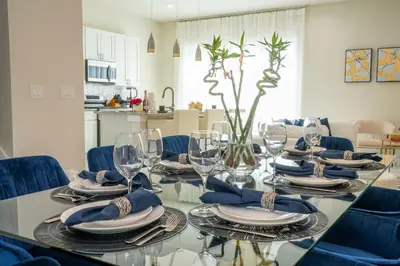 a dining room with a glass table and blue chairs at New Exclusive Villa 5 min to Disney in Orlando